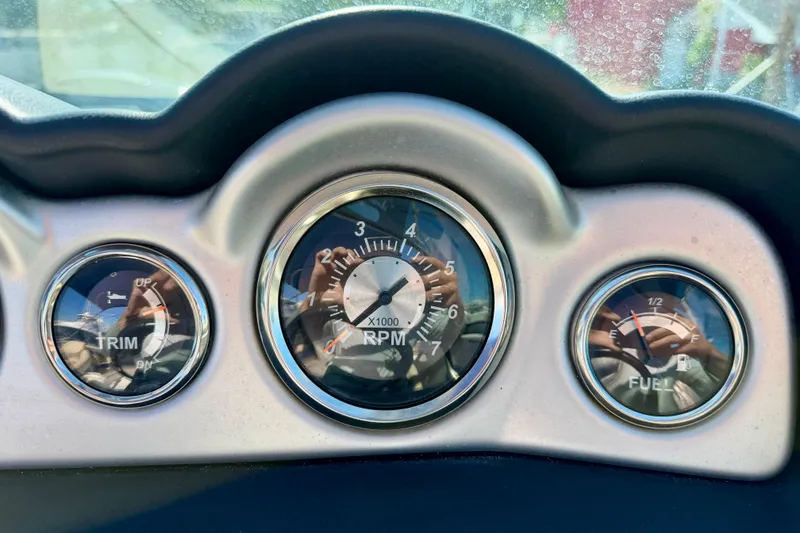 Slide: The Image of Dashboard gauges of a 2014 NauticStar 243DC Sport Deck boat, showing trim, RPM, and fuel levels. - 15