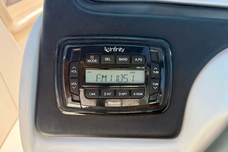 Slide: The Image of Infinity stereo system on 2014 NauticStar 243DC Sport Deck, displaying FM 105.1. - 16