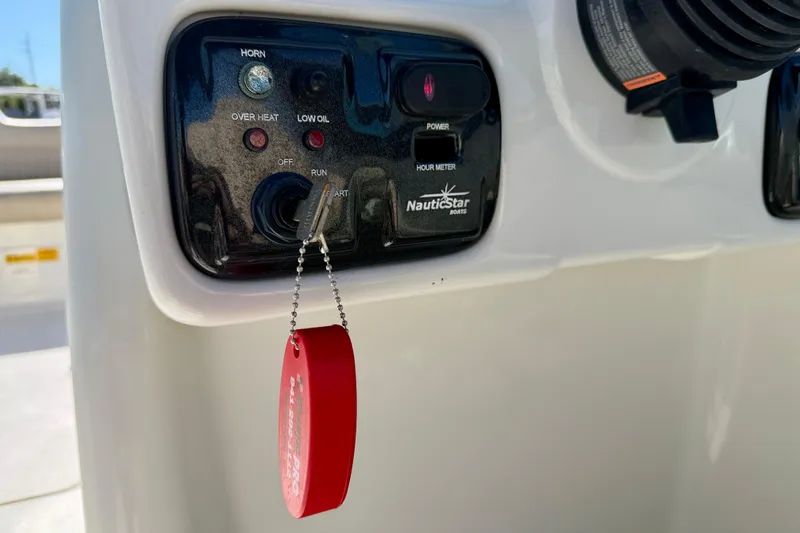 Slide: The Image of Control panel of a 2014 NauticStar 243DC Sport Deck boat with key and indicators. - 18
