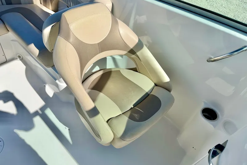Slide: The Image of 2014 NauticStar 243DC Sport Deck boat seat, beige and gray upholstery, cup holder nearby. - 19