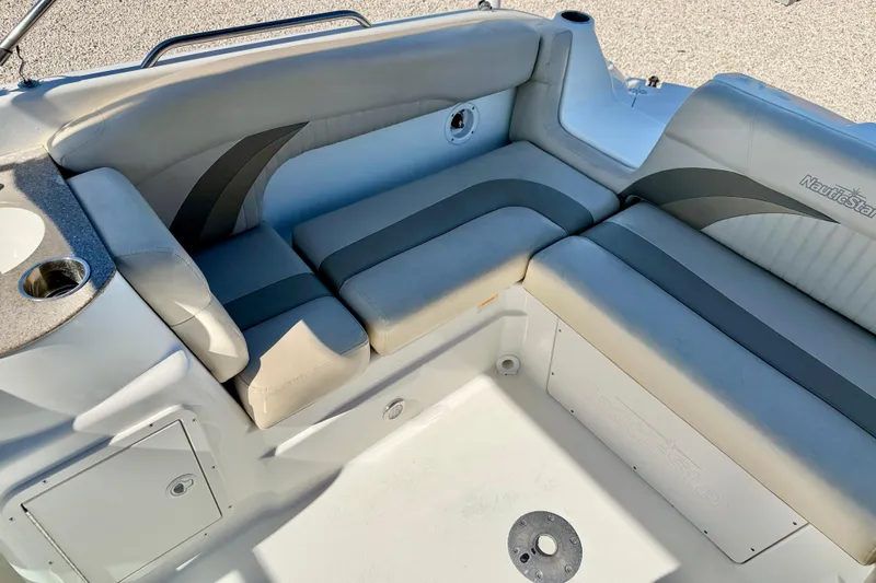 Slide: The Image of 2014 NauticStar 243DC Sport Deck boat interior with cushioned seating and cup holder. - 21