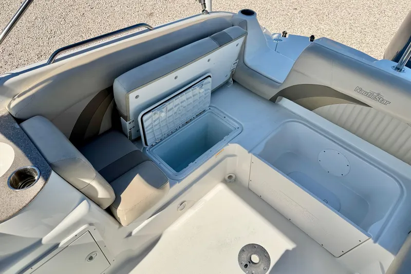 Slide: The Image of 2014 NauticStar 243DC Sport Deck boat interior with seating and storage compartments. - 25