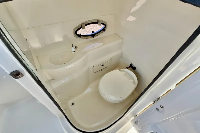 Slide: The Image of 2014 NauticStar 243DC Sport Deck boat interior bathroom with toilet and sink. - 27