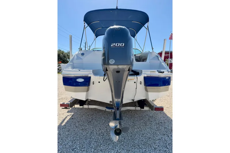 Slide: The Image of 2014 NauticStar 243DC Sport Deck boat with 200 horsepower engine, parked on gravel. - 32