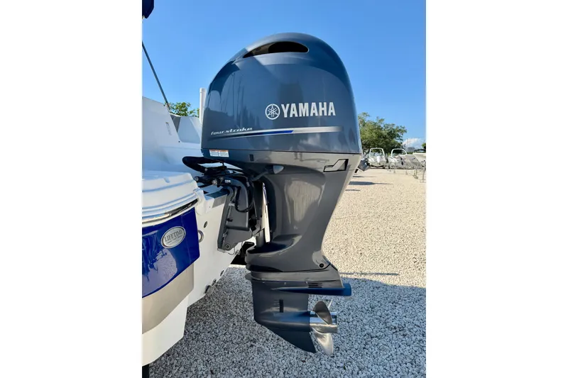 Slide: The Image of 2014 NauticStar 243DC Sport Deck with Yamaha outboard motor, parked on gravel. - 33