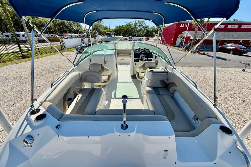 Slide: The Image of 2014 NauticStar 243DC Sport Deck boat with blue canopy and spacious seating. - 8