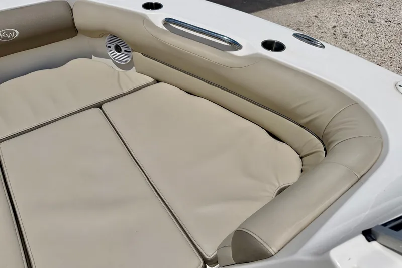 Slide: The Image of 2024 Key West 239 DFS boat interior with beige cushioned seating and speaker. - 11