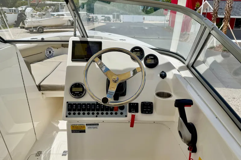 Slide: The Image of 2024 Key West 239 DFS boat dashboard with steering wheel and control panel. - 12