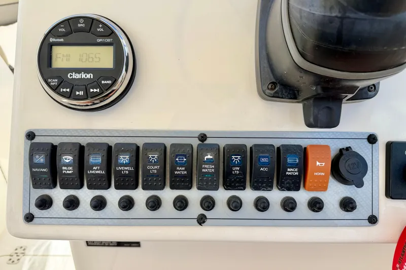 Slide: The Image of Control panel of 2024 Key West 239 DFS boat with switches and Clarion radio. - 13