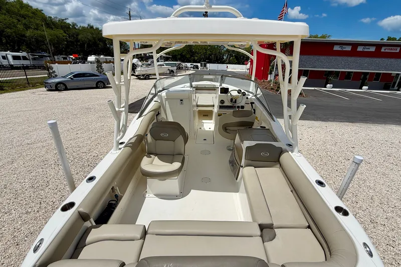 Slide: The Image of 2024 Key West 239 DFS boat interior with seating and helm, parked outdoors. - 19