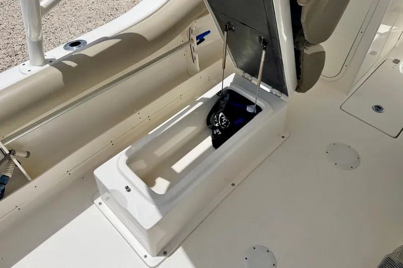 Slide: The Image of 2024 Key West 239 DFS boat storage compartment with open lid and gear inside. - 28