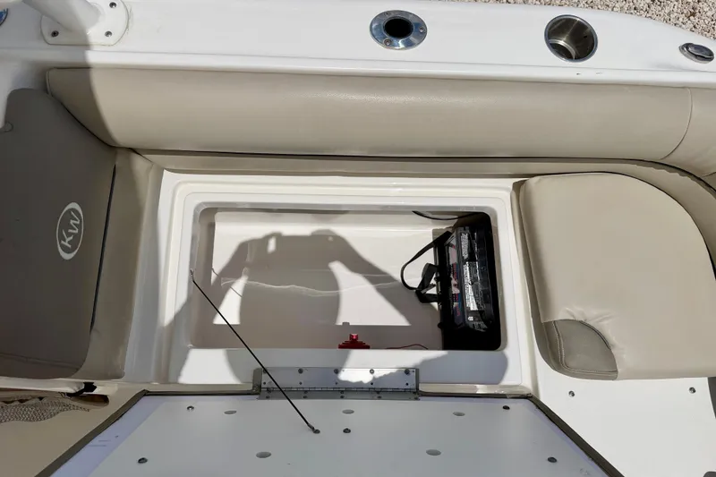 Slide: The Image of 2024 Key West 239 DFS boat storage compartment with battery and seating. - 29
