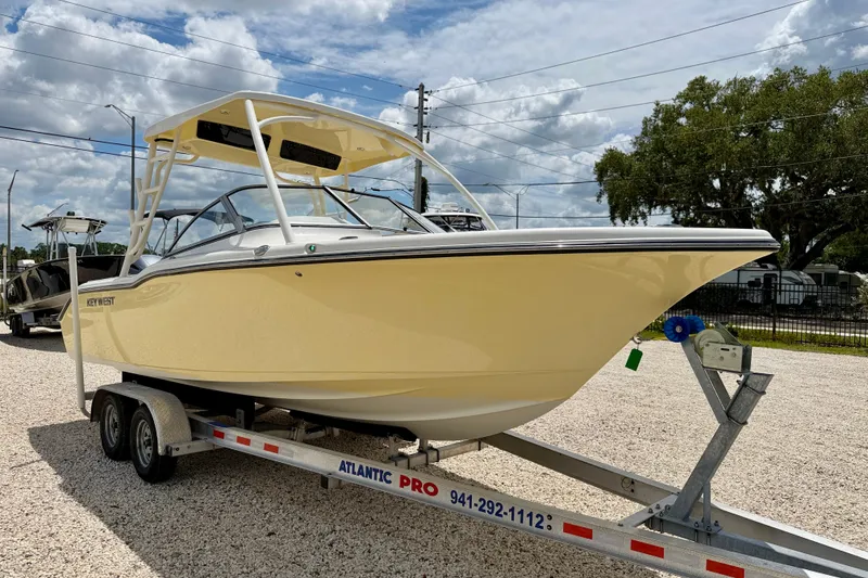 Slide: The Image of 2024 Key West 239 DFS boat on trailer, parked outdoors under cloudy sky. - 3
