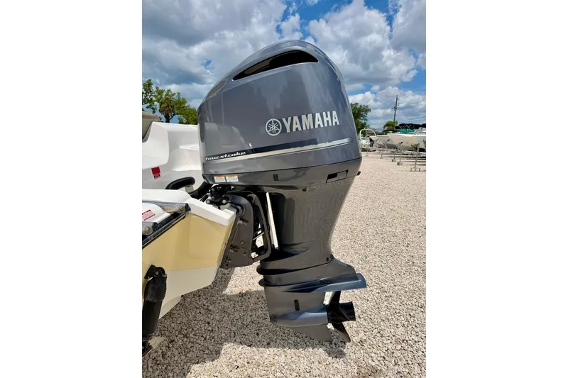 Slide: The Image of 2024 Key West 239 DFS boat with Yamaha four-stroke outboard motor, parked on gravel. - 31