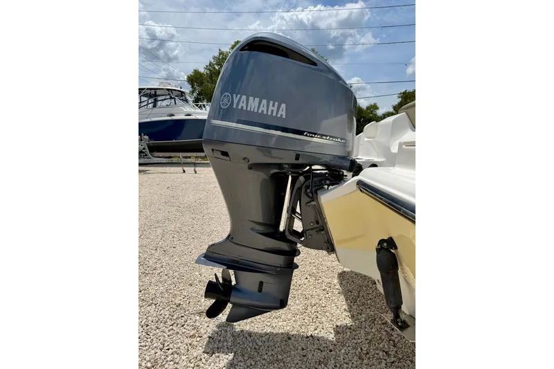 Slide: The Image of 2024 Key West 239 DFS boat with Yamaha outboard motor, parked on gravel. - 33