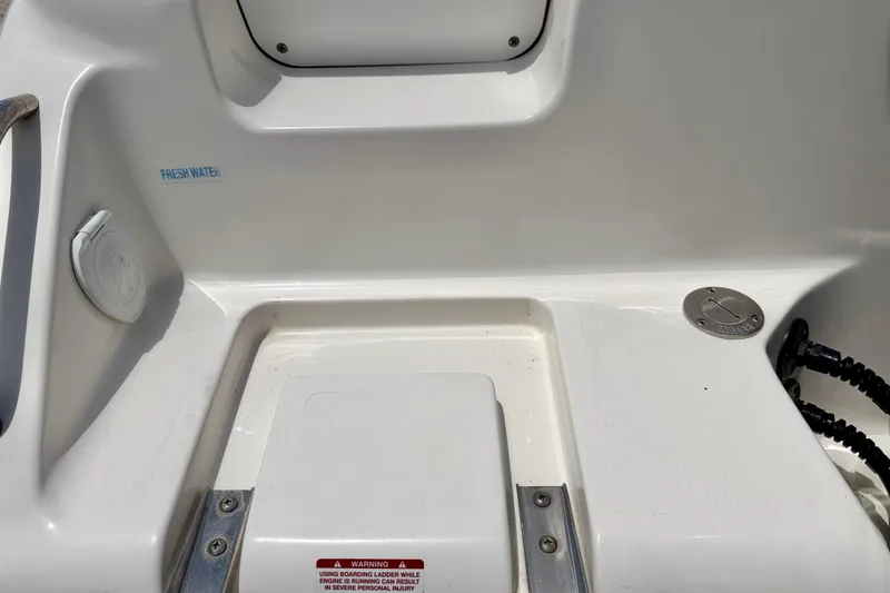 Slide: The Image of 2024 Key West 239 DFS boat deck with fresh water access and warning label. - 34