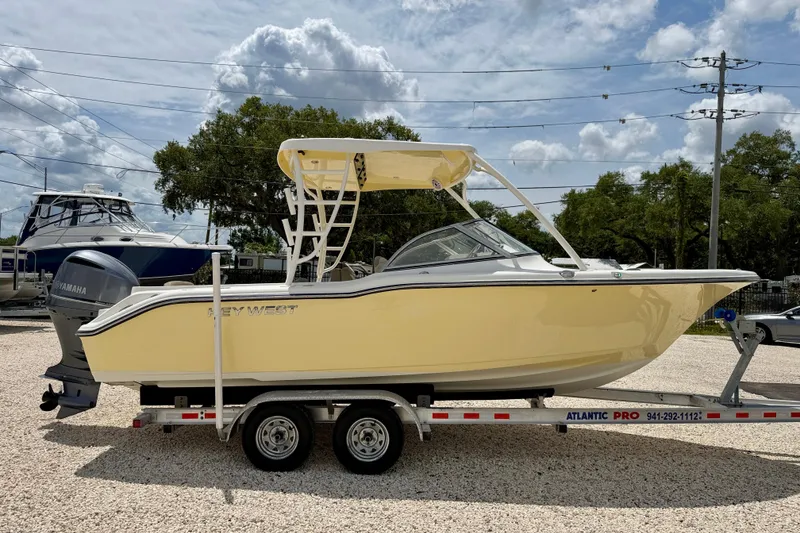 Slide: The Image of 2024 Key West 239 DFS boat on trailer, yellow hull, parked outdoors. - 4