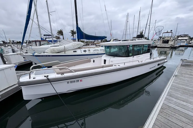 The Image of 2022 Axopar 28 Cabin boat cruising on open blue sea. - 0