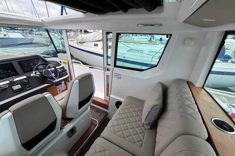 Slide: The Image of Interior of 2022 Axopar 28 Cabin boat with luxurious seating and marina view. - 10