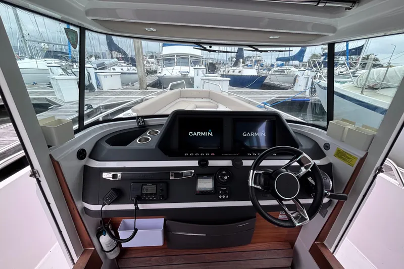 Slide: The Image of 2022 Axopar 28 Cabin dashboard with Garmin navigation system and steering wheel. - 15