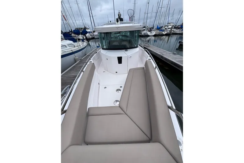 Slide: The Image of 2022 Axopar 28 Cabin boat with spacious seating at a marina dock. - 17