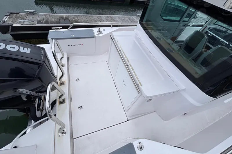 Slide: The Image of 2022 Axopar 28 Cabin boat docked, featuring sleek design and comfortable seating. - 18