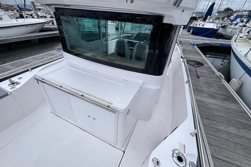 Slide: The Image of 2022 Axopar 28 Cabin boat deck with Mercury engine and seating area. - 19