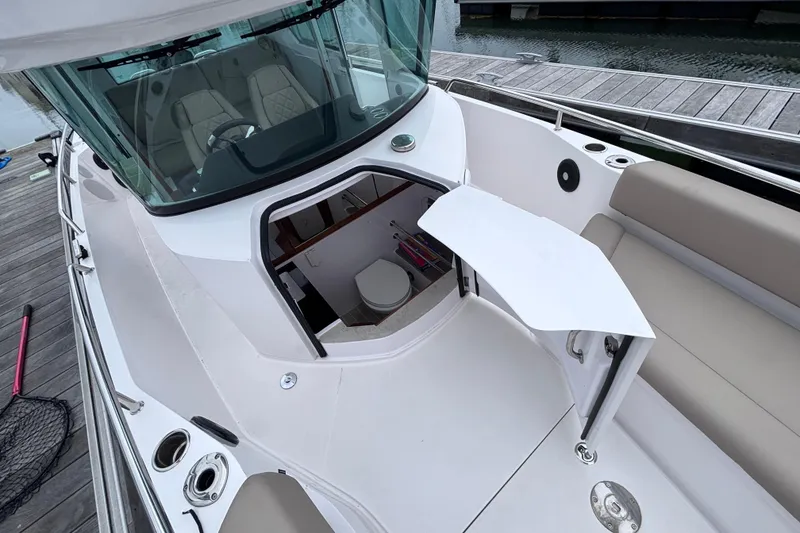 Slide: The Image of 2022 Axopar 28 Cabin boat docked at a marina, showcasing sleek design and spacious deck. - 20