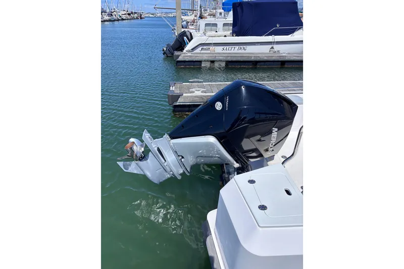 Slide: The Image of 2022 Axopar 28 Cabin boat docked in a marina, surrounded by other vessels. - 6