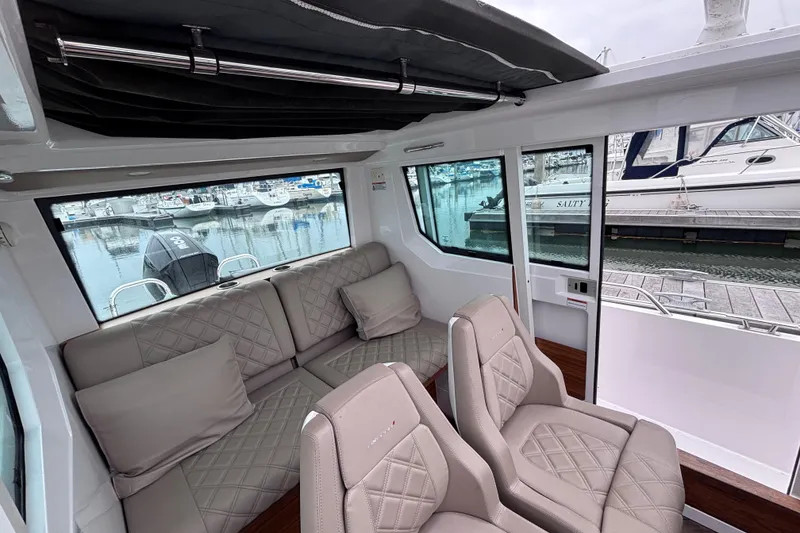 Slide: The Image of Luxurious interior of 2022 Axopar 28 Cabin boat with plush seating and modern dashboard. - 9
