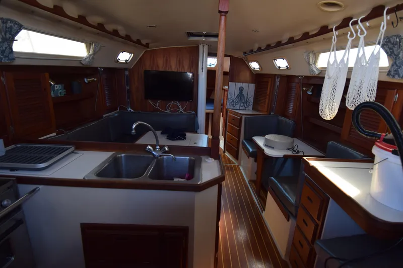 Slide: The Image of Interior of a 1989 Catalina 36 sailboat featuring a cozy kitchen and dining area. - 10