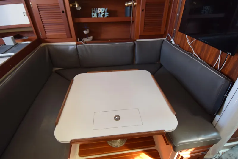 Slide: The Image of Cozy dining area in a 1989 Catalina 36 sailboat with cushioned seating and table. - 13