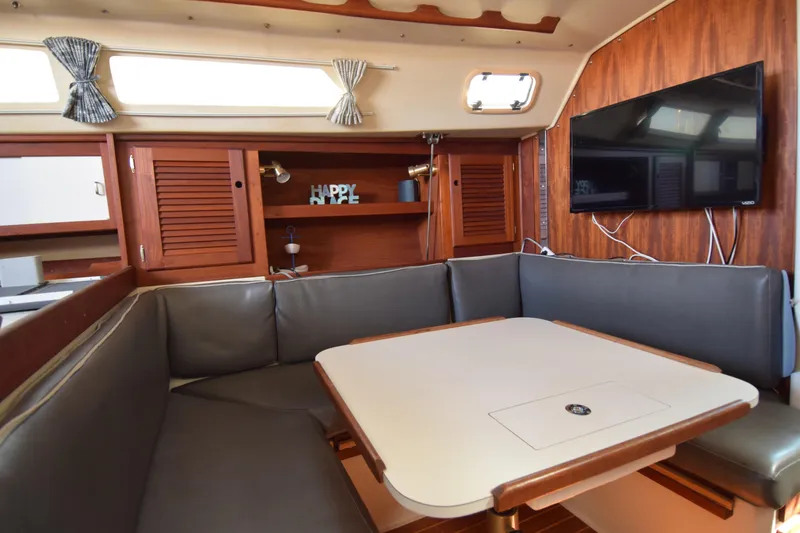 Slide: The Image of Interior of 1989 Catalina 36 sailboat with cozy dining area and mounted TV. - 15