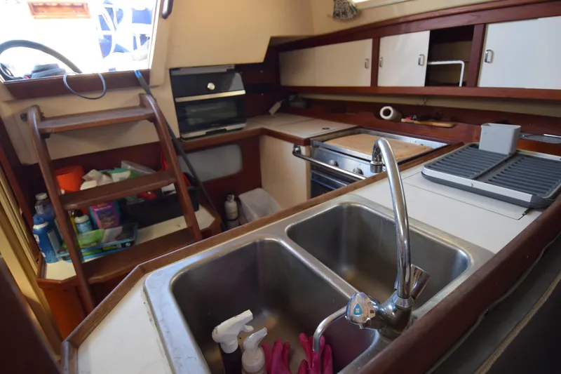 Slide: The Image of Interior of 1989 Catalina 36 sailboat kitchen with sink, stove, and storage shelves. - 16