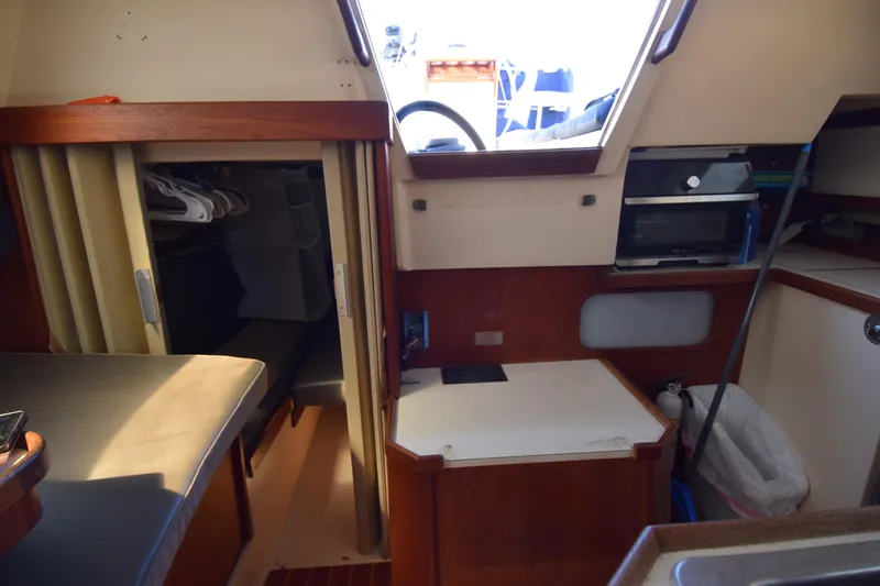 Slide: The Image of Interior of a 1989 Catalina 36 sailboat, featuring a cozy cabin with storage and seating. - 17