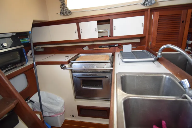 Slide: The Image of 1989 Catalina 36 yacht kitchen with stove, sink, and wooden cabinetry. - 20