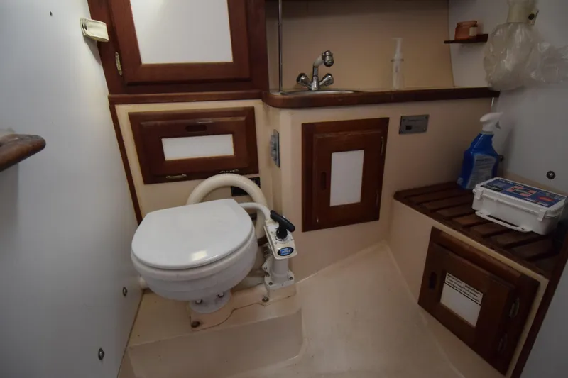 Slide: The Image of 1989 Catalina 36 yacht bathroom with toilet, sink, and wooden cabinetry. - 22