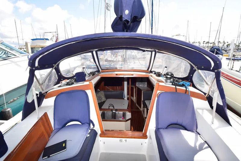Slide: The Image of 1989 Catalina 36 sailboat cockpit with blue cushions and marina view. - 30