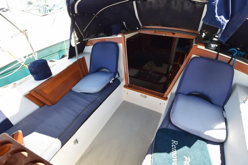 Slide: The Image of Interior view of a 1989 Catalina 36 sailboat cockpit with blue cushions and wooden accents. - 4