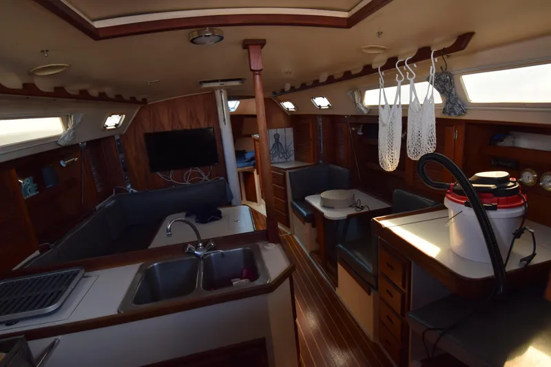 Slide: The Image of Interior of 1989 Catalina 36 sailboat with kitchen, seating, and storage areas. - 6