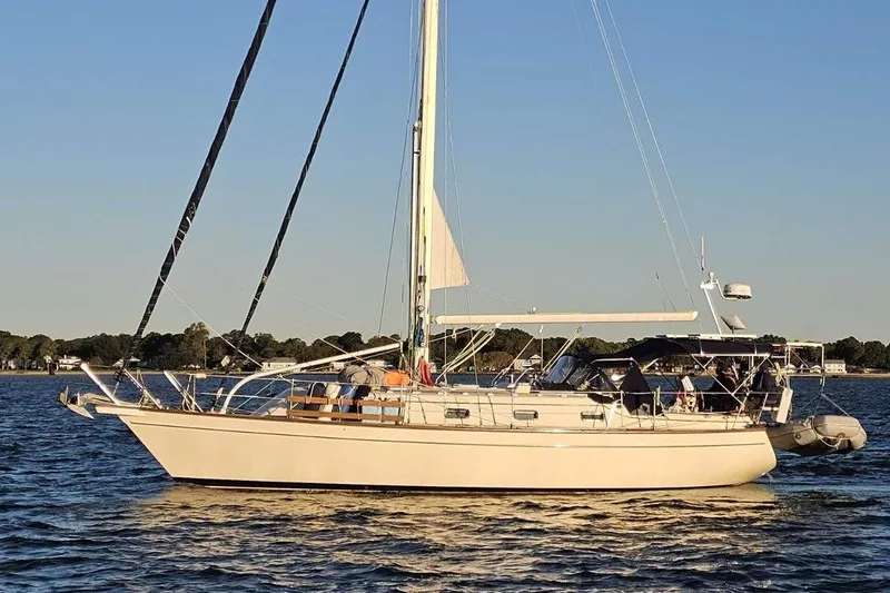 The Image of 2001 Island Packet 380 sailboat on calm water during sunset. - 0