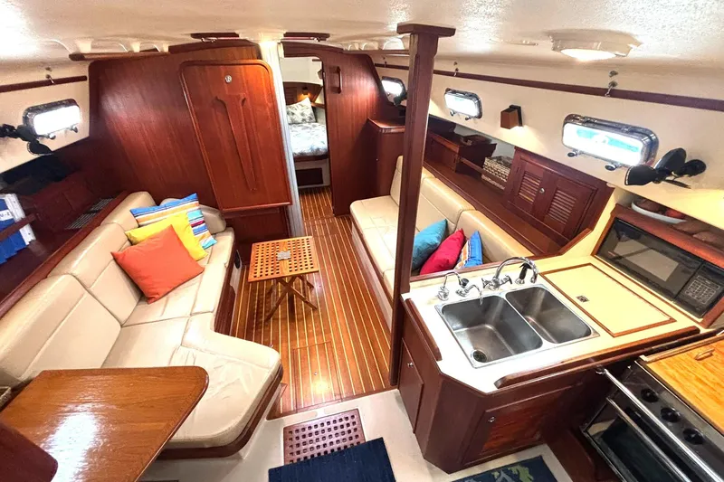 Slide: The Image of Interior of 2001 Island Packet 380 sailboat with cozy seating and kitchen area. - 2