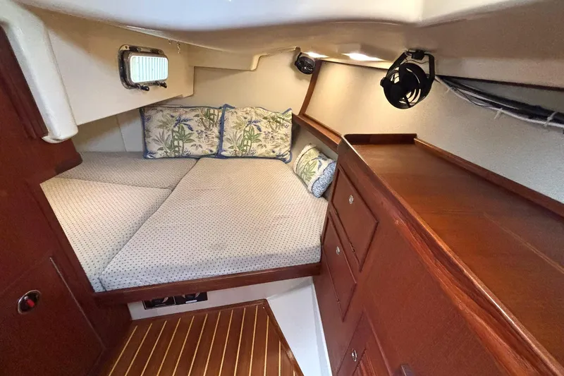 Slide: The Image of Cozy cabin interior of 2001 Island Packet 380 sailboat with wooden cabinetry and patterned bedding. - 20