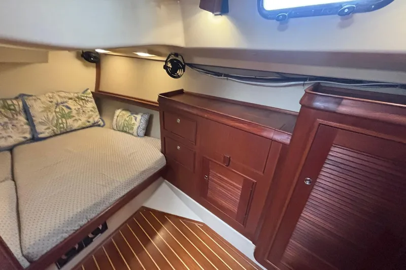 Slide: The Image of Cozy cabin interior of 2001 Island Packet 380 sailboat with wooden cabinetry and bedding. - 21