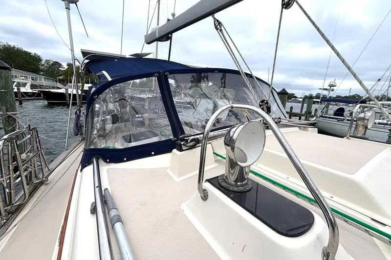 Slide: The Image of 2001 Island Packet 380 sailboat docked, featuring a covered cockpit and stainless steel fittings. - 34