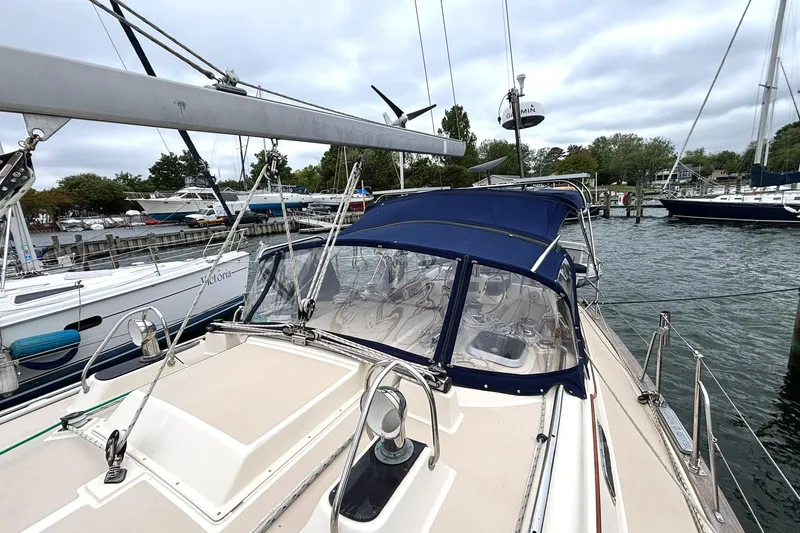 Slide: The Image of 2001 Island Packet 380 sailboat docked, featuring blue canopy and clear cockpit enclosure. - 35
