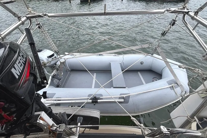 Slide: The Image of Inflatable dinghy secured on Island Packet 380 sailboat, 2001 model, with Mercury outboard motor. - 36