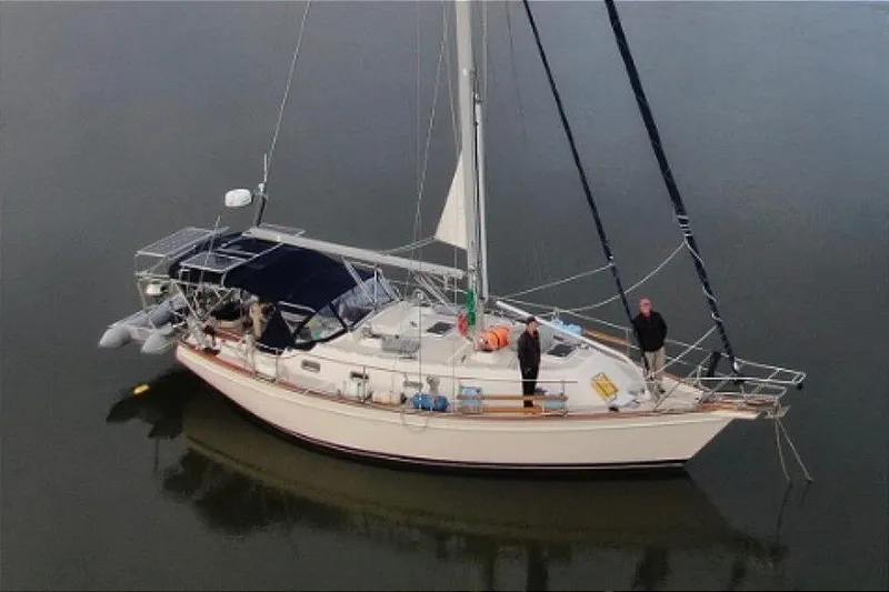 Slide: The Image of 2001 Island Packet 380 sailboat on calm water with two people on deck. - 37