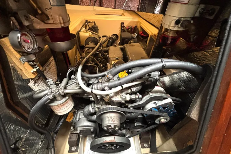 Slide: The Image of Engine compartment of a 2001 Island Packet 380 sailboat, showcasing mechanical components and hoses. - 38
