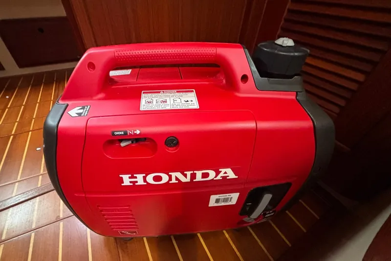 Slide: The Image of Red Honda generator on wooden floor of Island Packet 380 yacht, 2001 model. - 44